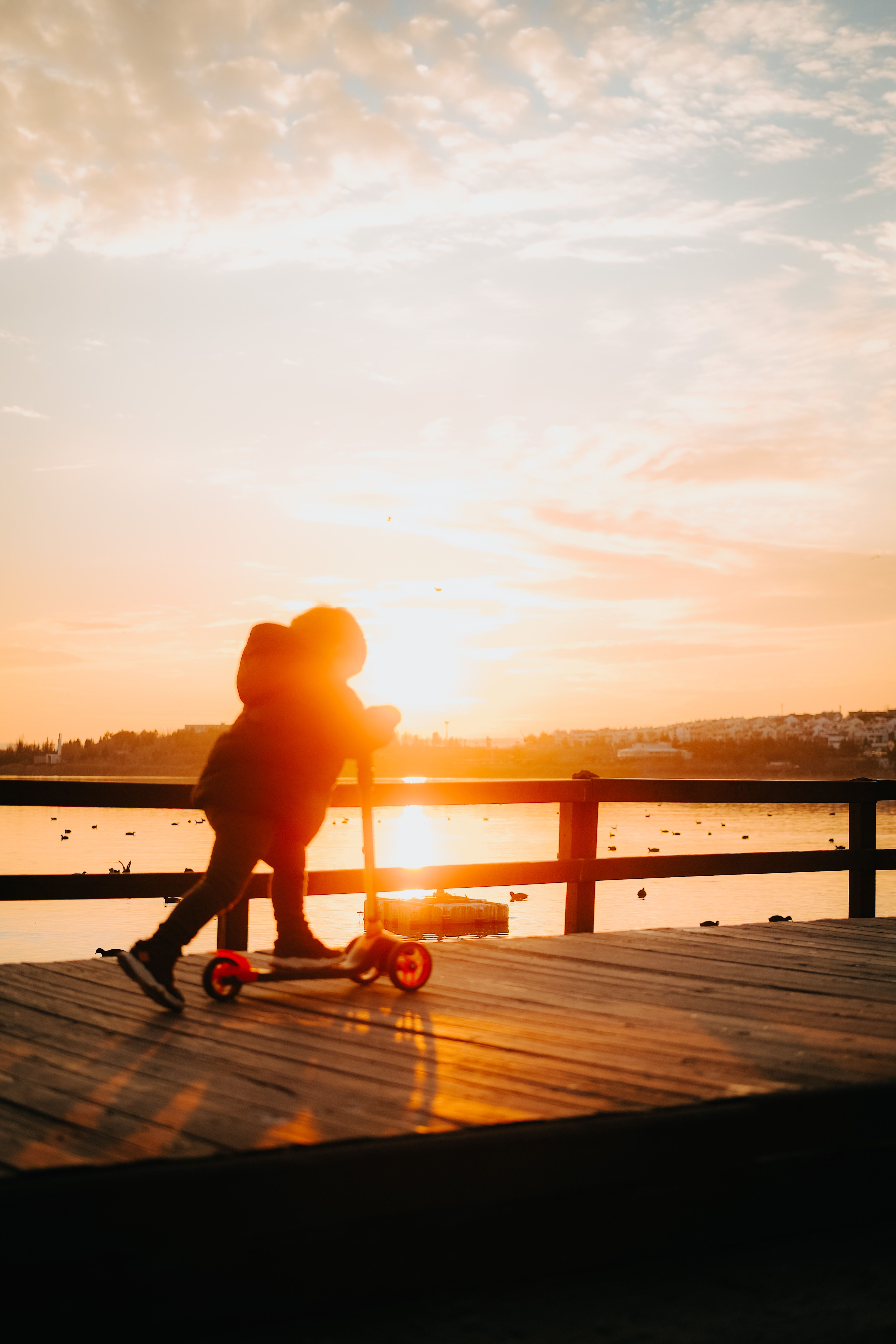 A child on a scooter at golden hour